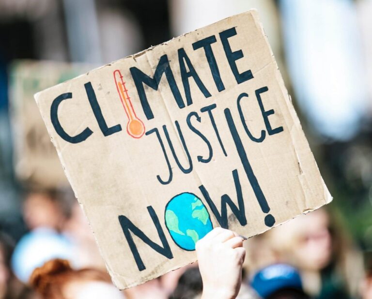 sign reading "climate justice now!"