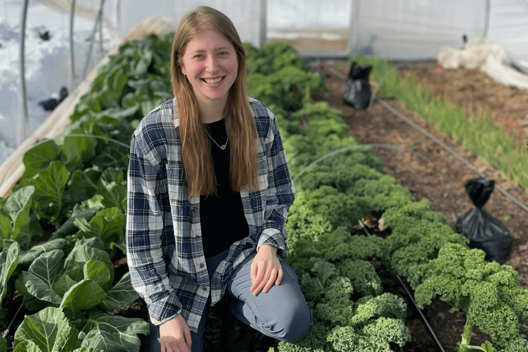 Olivia Olson smiling in a greenhouse
