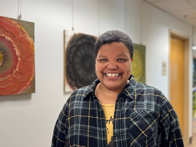 Victoria McWane-Creek stand in the hallway at West Central Initiative smiling.