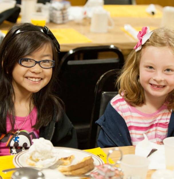 little girls smiling at lunch