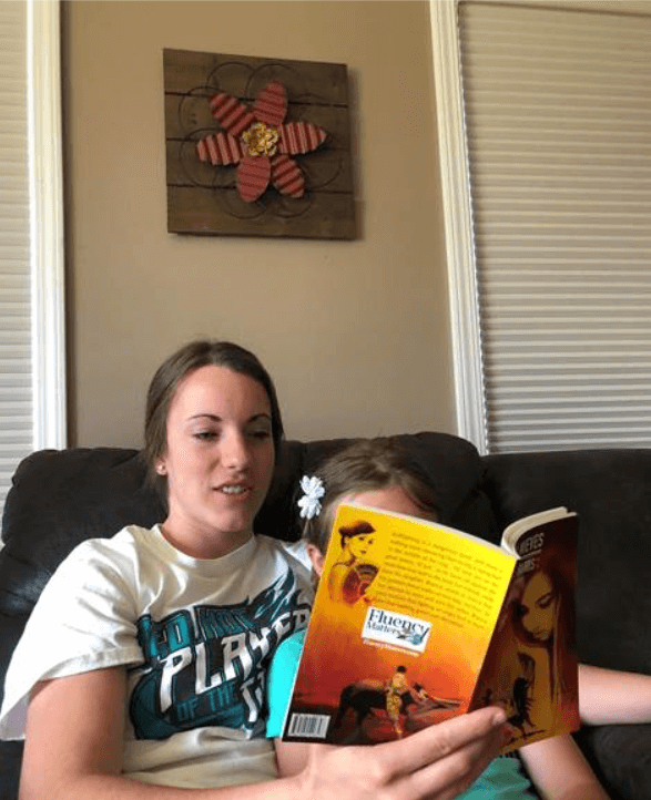 young woman reading a book to a child