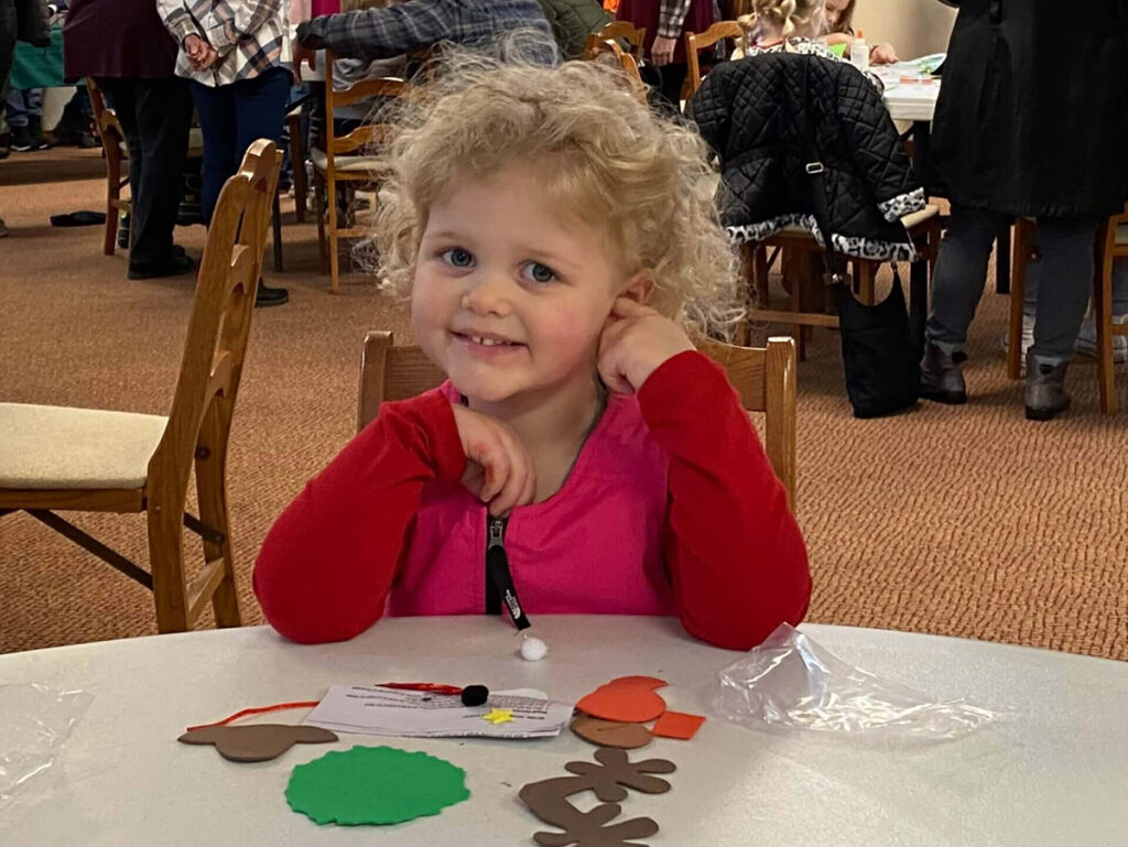little girl smiling and crafting