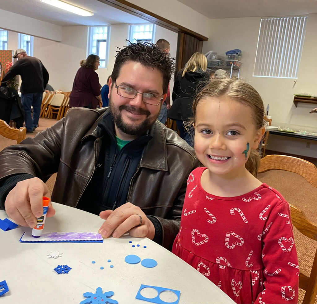 man and little girl smiling and coloring