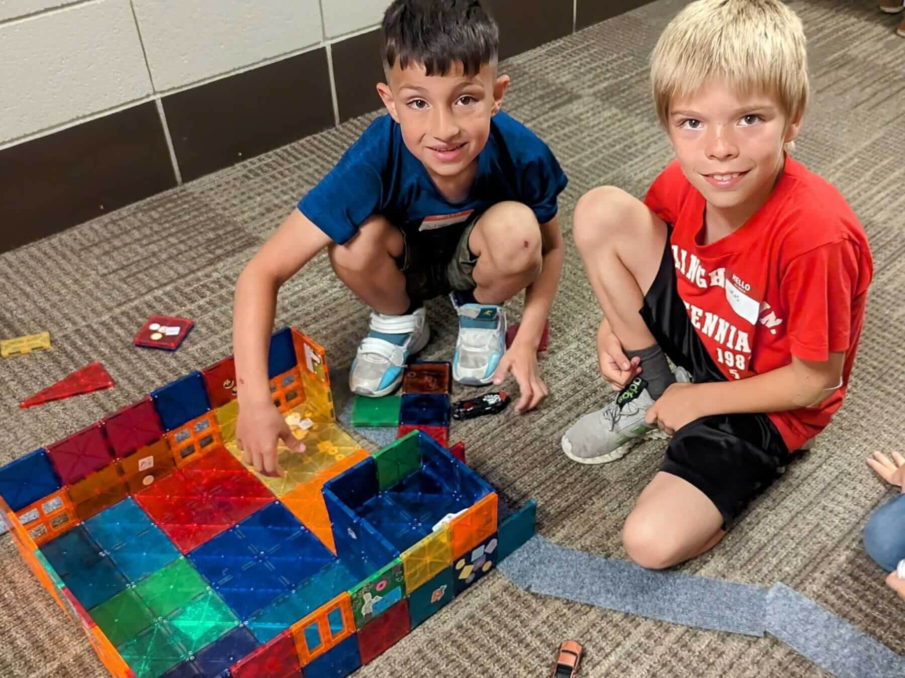 2 kids playing with toys on ground