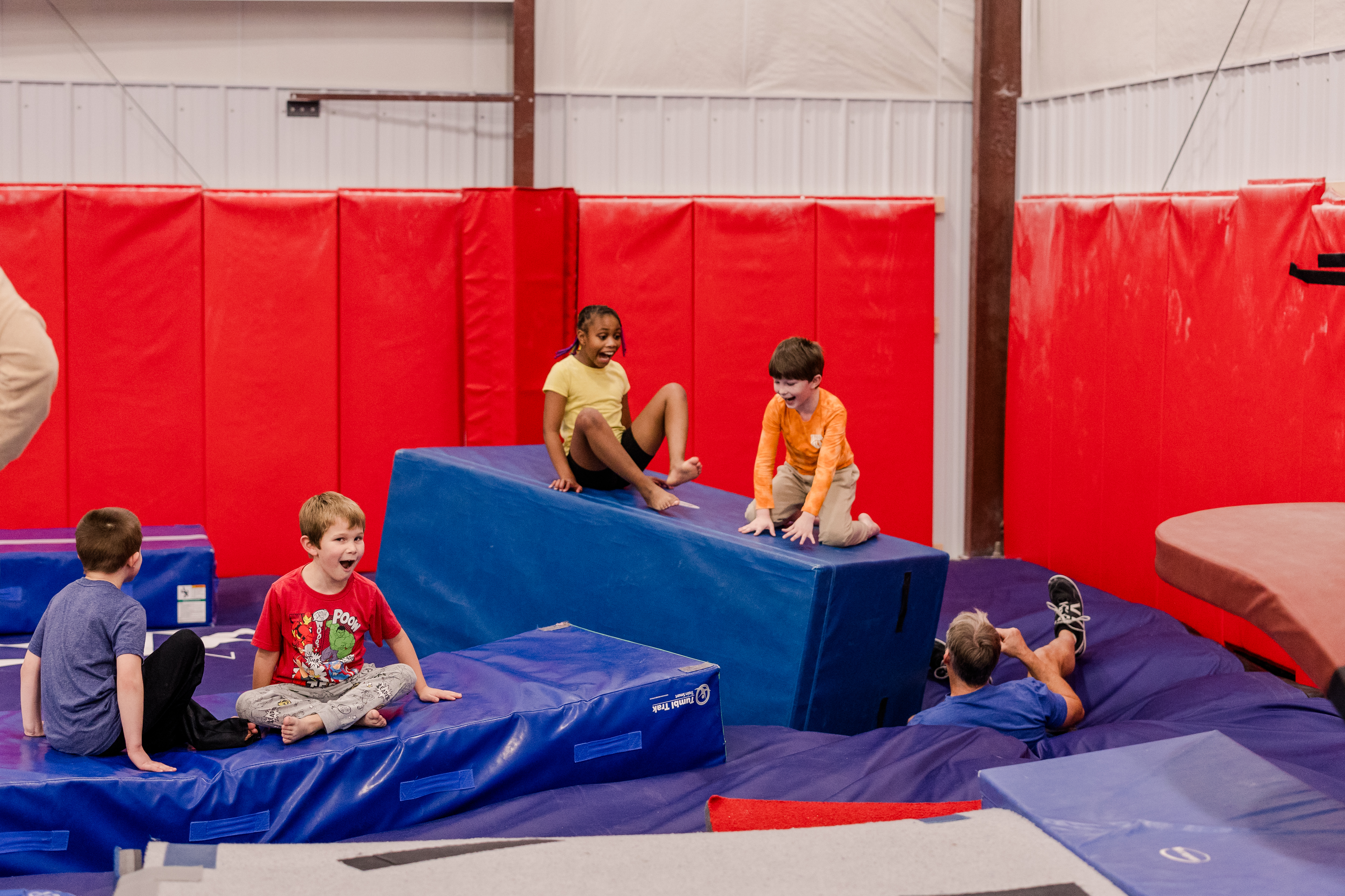 Kids playing on gymanstics equipment.